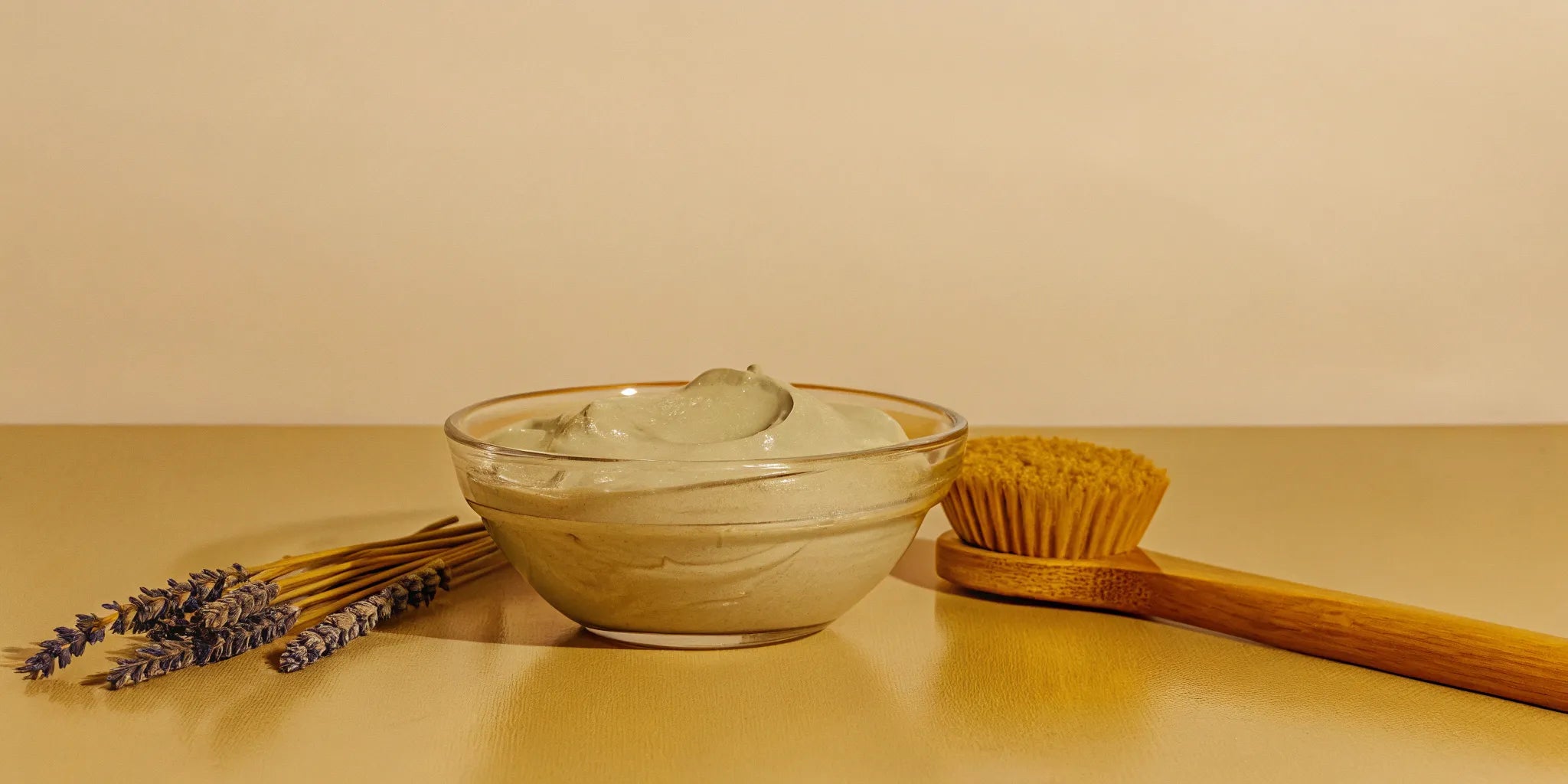 A gentle type of facial for sensitive skin, with a bowl of soothing cream, lavender, and a soft brush.