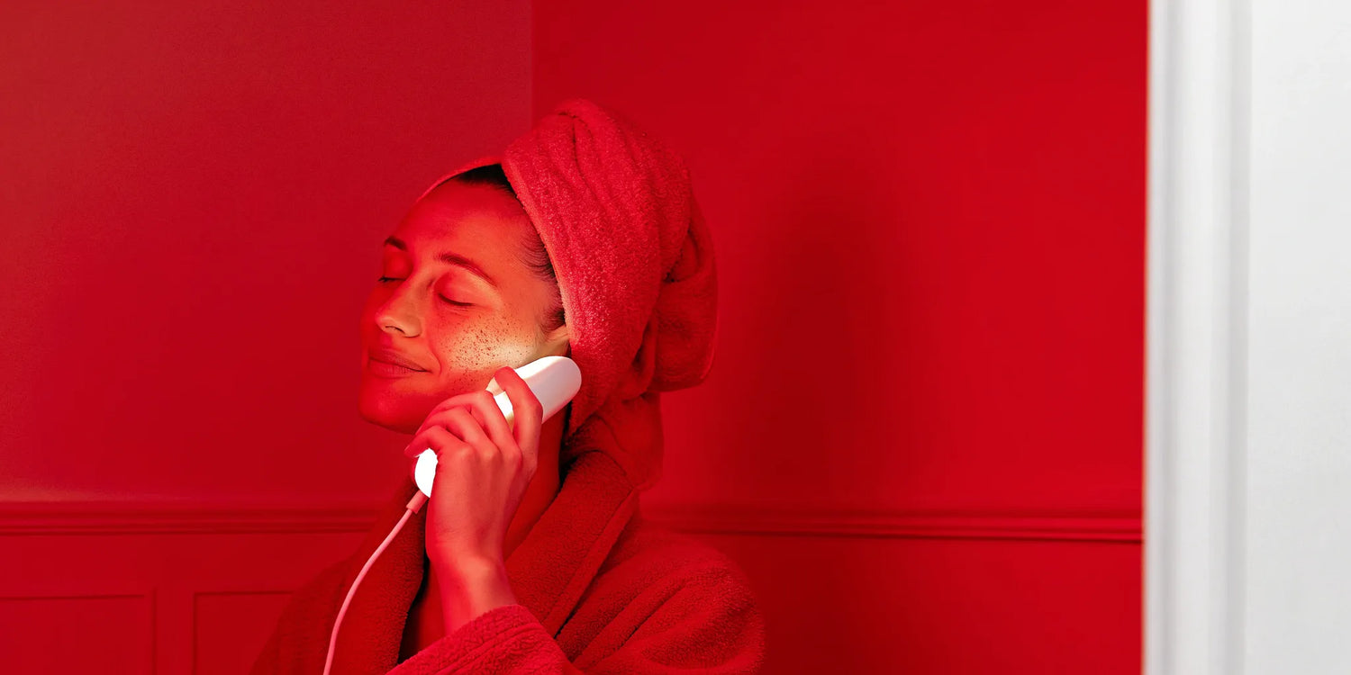Woman using red light therapy device.