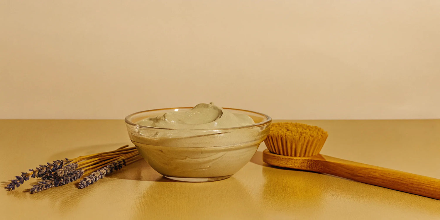 A gentle type of facial for sensitive skin, with a bowl of soothing cream, lavender, and a soft brush.